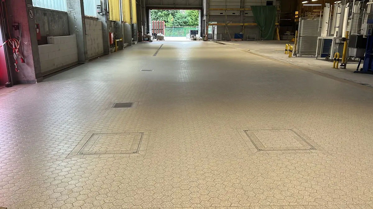 Industriële tegelvloer uitgerust met afvoergoten, vloerputten en inspectieluiken