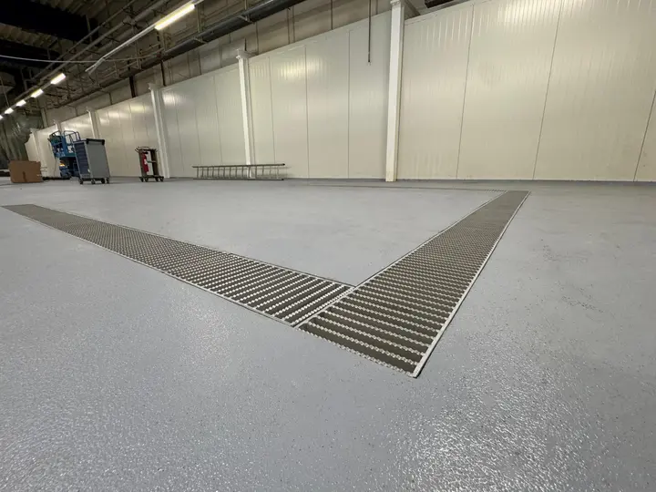 Afvoerkanaal met een breedte van 300 mm en ladderroosterafdekking in een farmaceutische fabriek